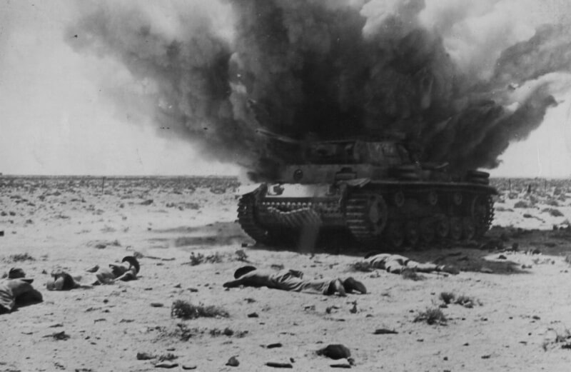 Австралийские солдаты укрываются от прямого попадания в брошенный немецкий танк